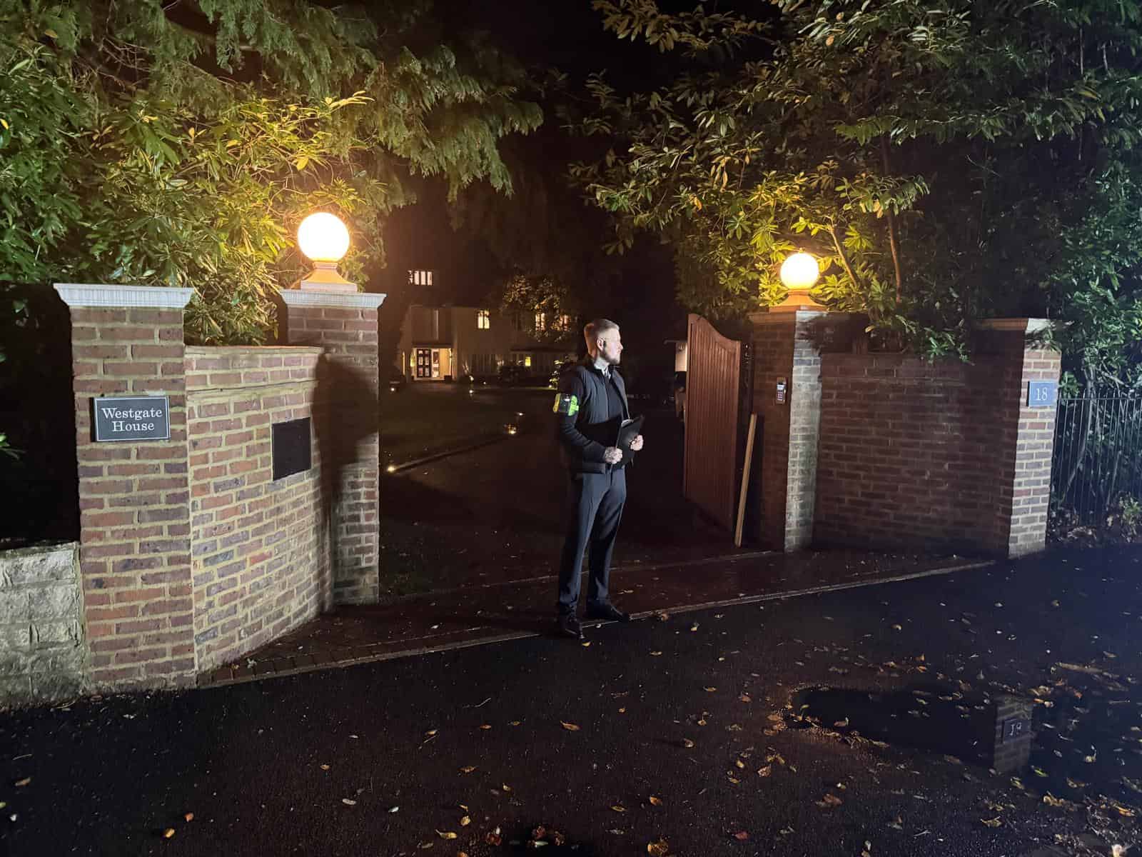 Security guard standing at entrance gate at night in Bournemouth & Poole.